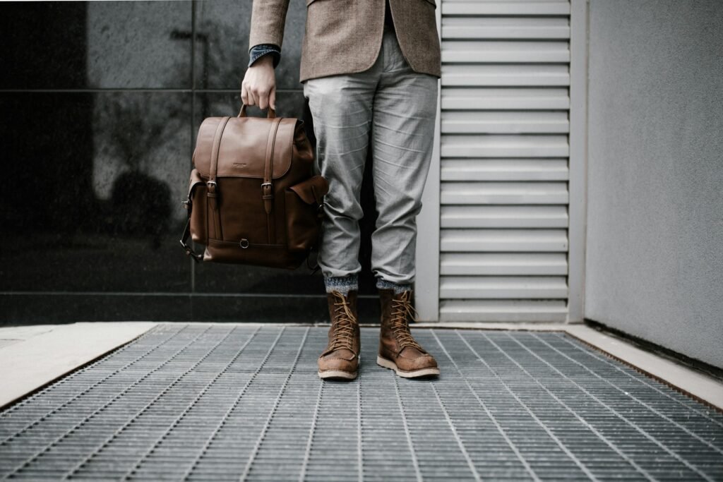 Man wearing boot and carrying leather bag